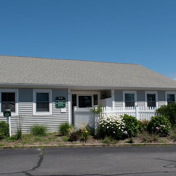 a white house with a white picket fence and white flowers in front of it