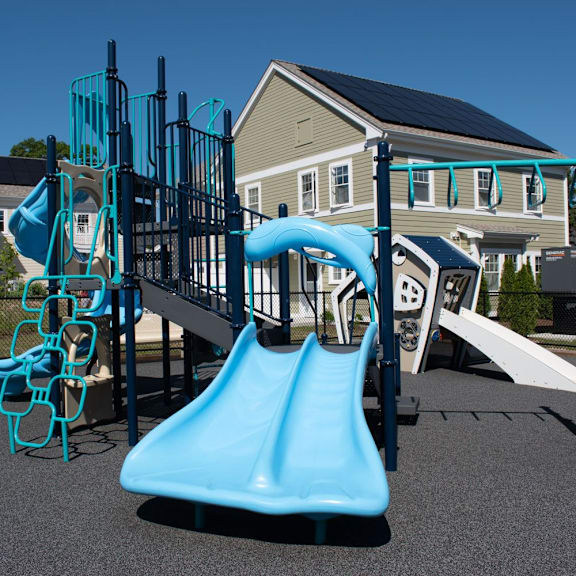 a playground with a blue slide and climbing equipment