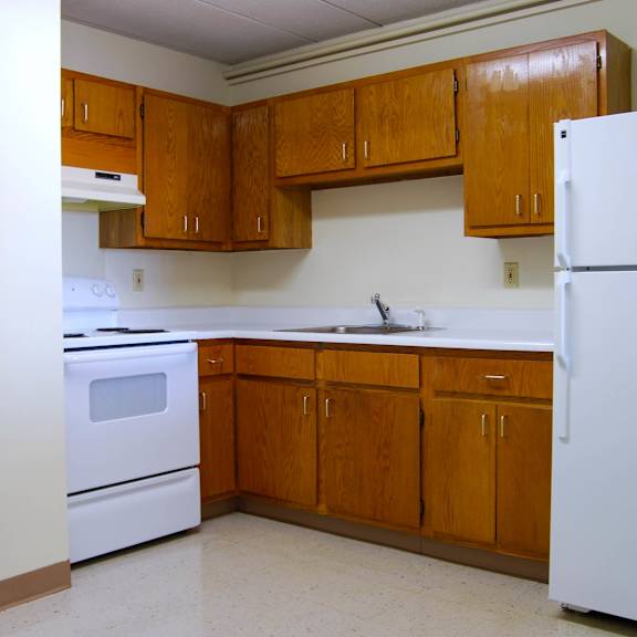 a kitchen with white appliances and wooden cabinets.