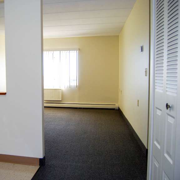 a white refrigerator sits in a room with a window and a door.