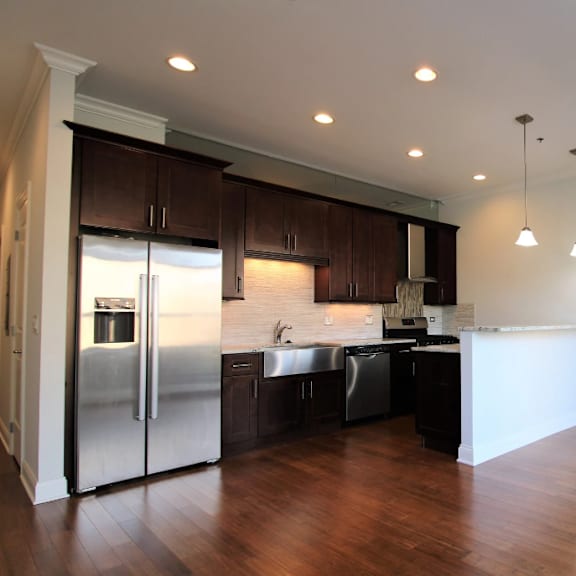a renovated kitchen with stainless steel appliances and wooden floors