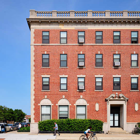 a red brick building with a balcony on the top floor.