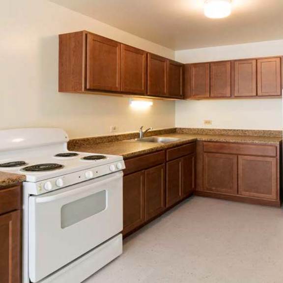 a kitchen with white appliances and brown cabinets.