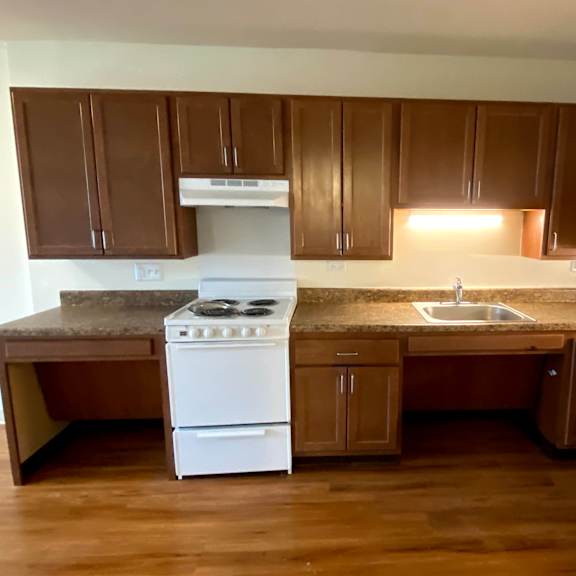 a kitchen with brown cabinets and a white stove.