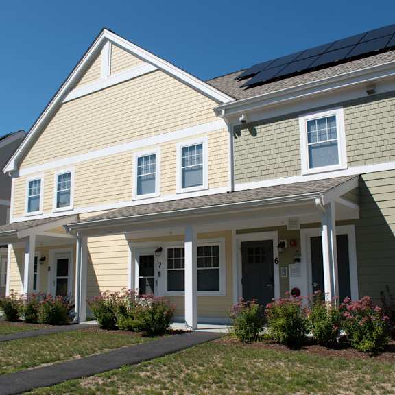 a row of houses with solar panels on the roof