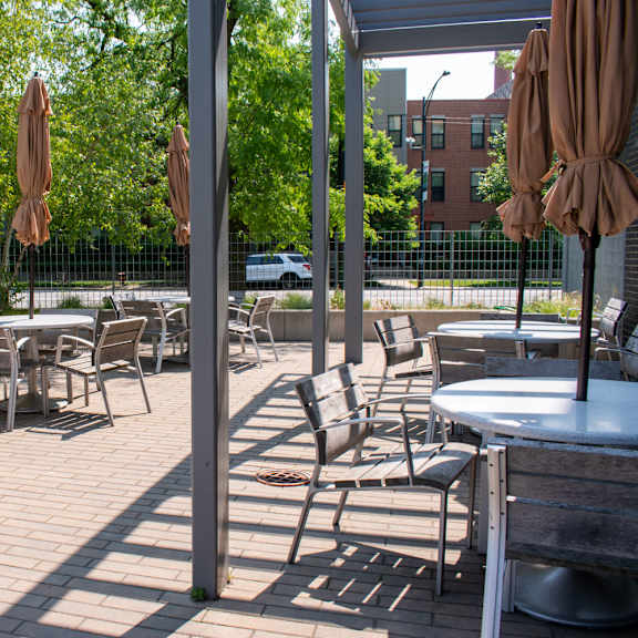 a patio with tables and chairs and umbrellas