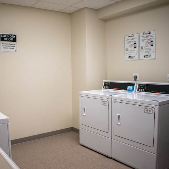 a laundry room with four washers and two dryers