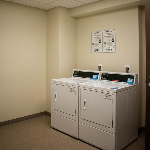 a room with two washers and two dryers
