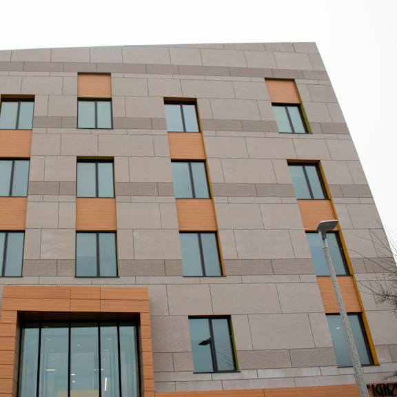 a building with a grey facade and orange accents.