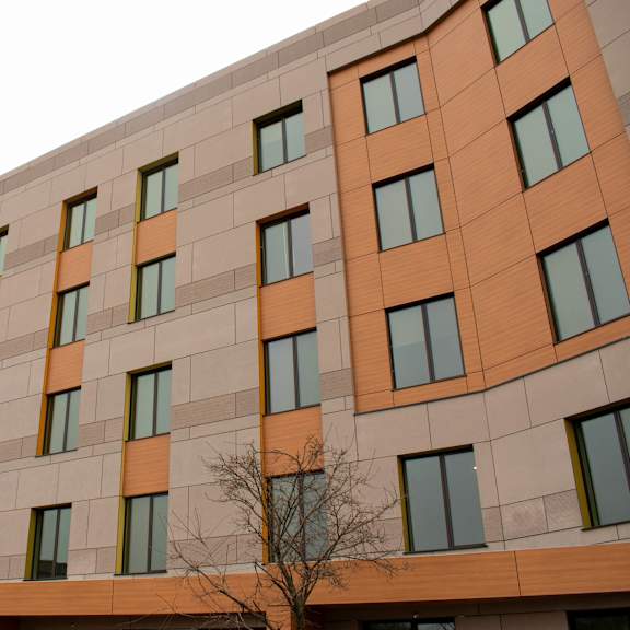 a tall building with orange and beige panels and windows.