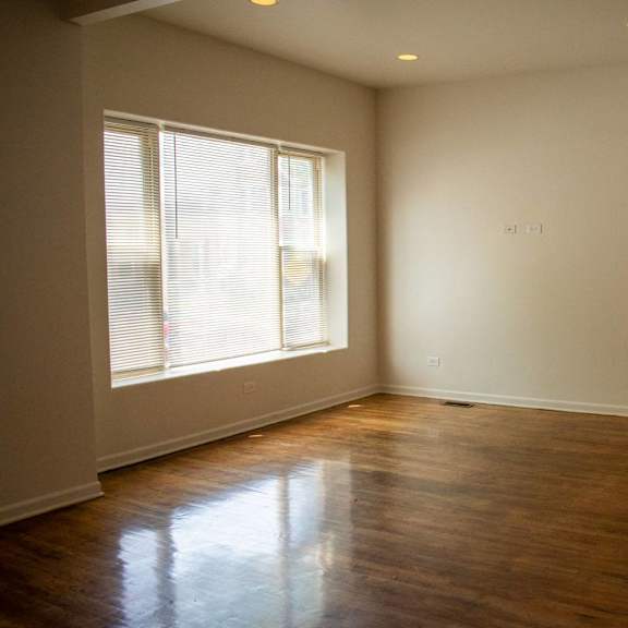 an empty living room with a staircase and a window