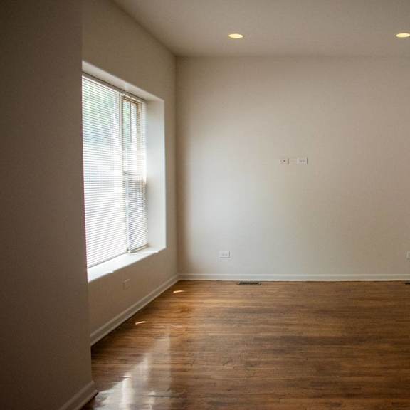 a room with a crib and a window and a wooden floor