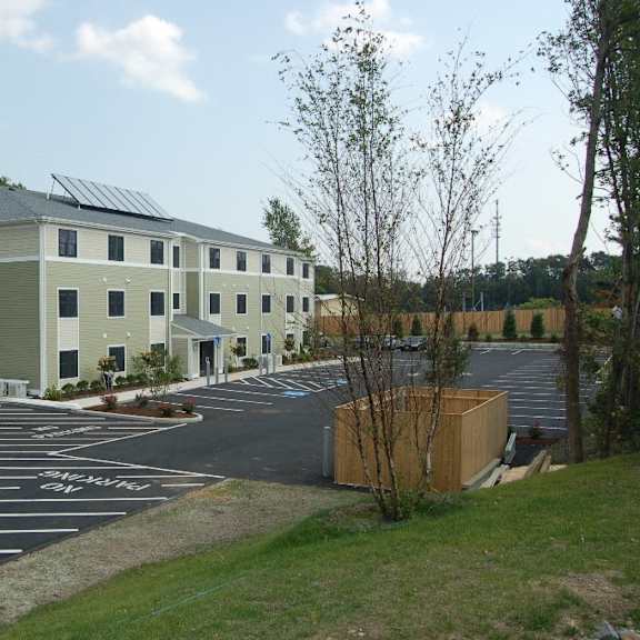 a building with solar panels on the roof and a parking lot