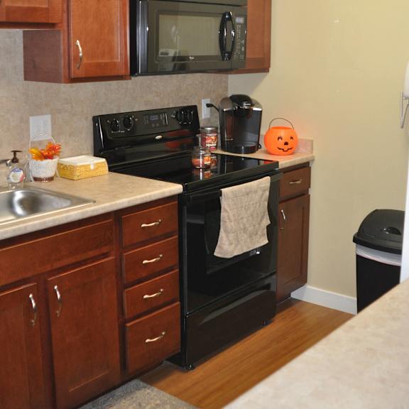 a kitchen with black appliances and wooden cabinets