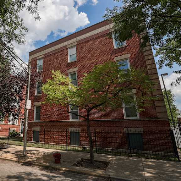 a red brick building with a tree in front of it.