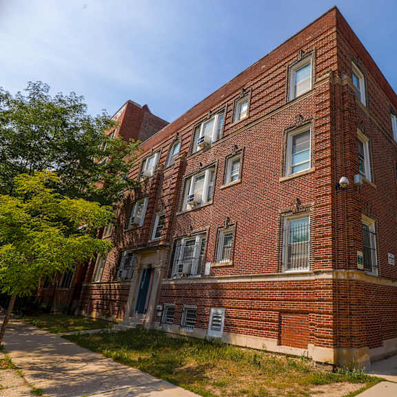 a red brick building with a tree in front.