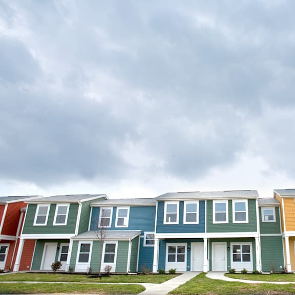 a row of houses in front of a cloudy sky