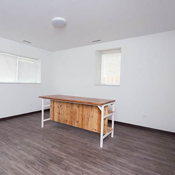 a room with a wooden table and two windows.