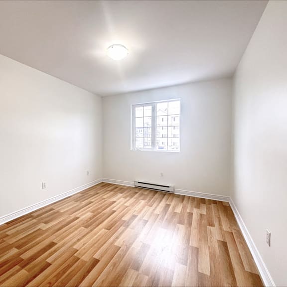 a room with wooden flooring and a window.