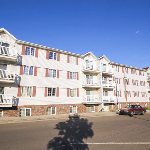 apartment building with a car parked in front.