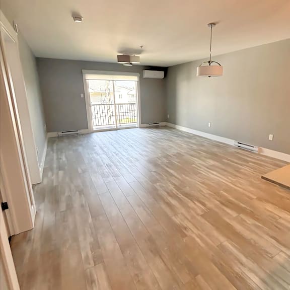 a room with wooden flooring and a large window.