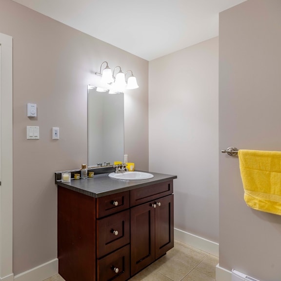 a bathroom with a sink, mirror, and lighting fixture.