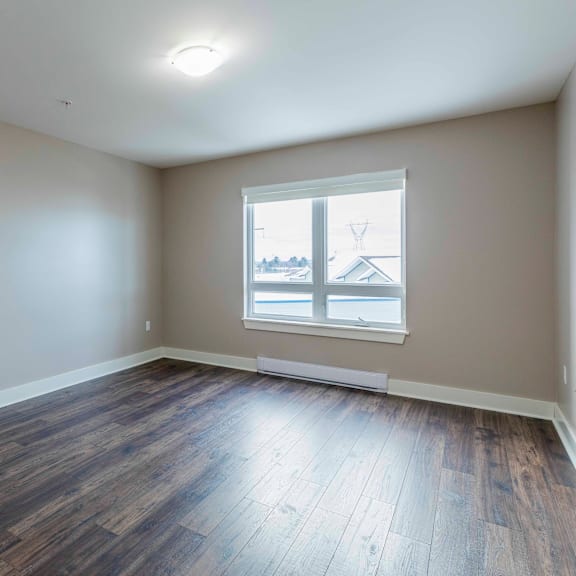 a room with a window and wooden flooring.