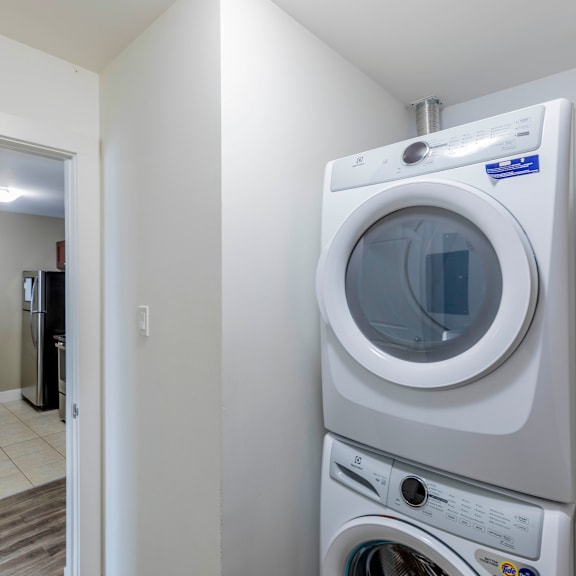 a white front loading washing machine in a laundry room.