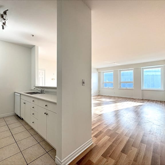 a kitchen with white cabinets and a wooden floor.