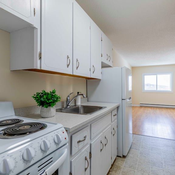 a kitchen with white cabinets and a stove top oven.