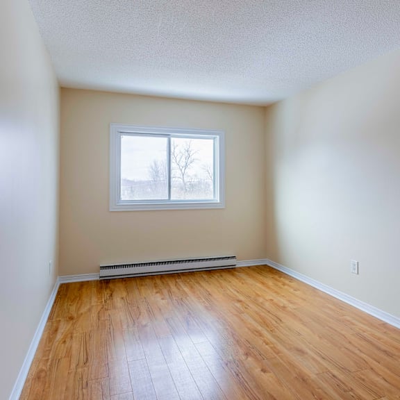 empty room with a window and wooden floor.