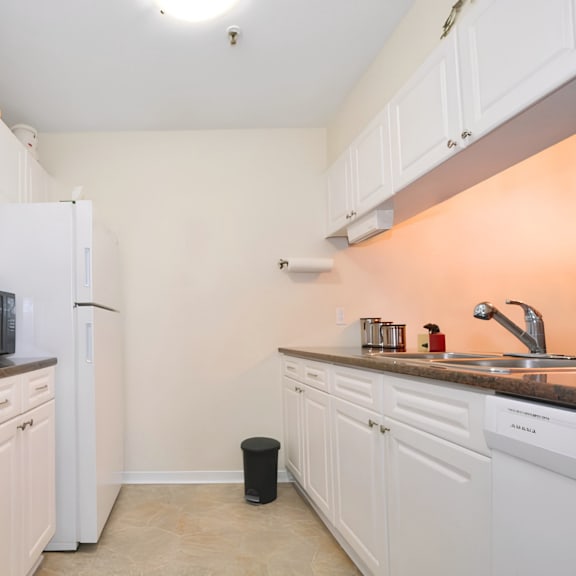a kitchen with white cabinets and appliances.