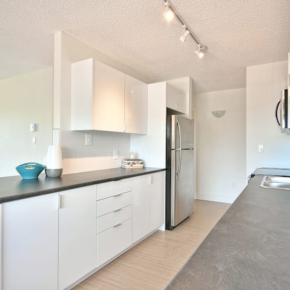 a kitchen with white cabinets and a stainless steel refrigerator.