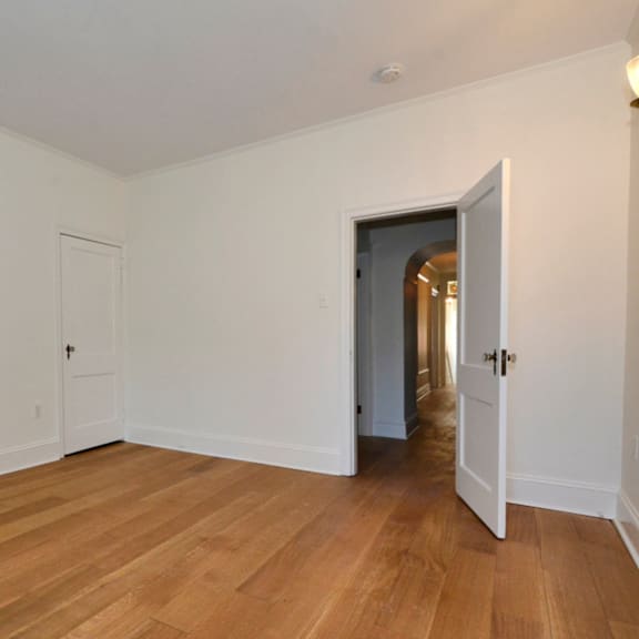 a room with a wooden floor and white walls.