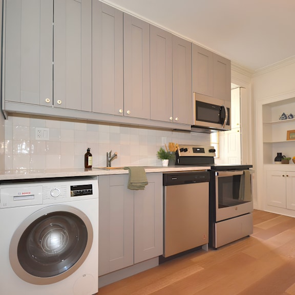 a modern kitchen with a washing machine and a microwave.