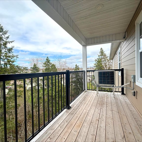 a balcony with a black railing and a wooden floor.