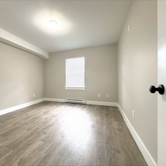 a room with a window and a wooden floor.