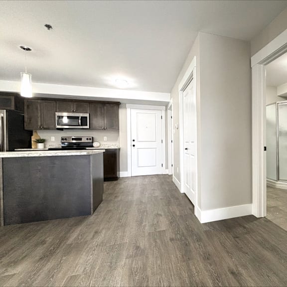 a kitchen with a dark countertop and a white door.