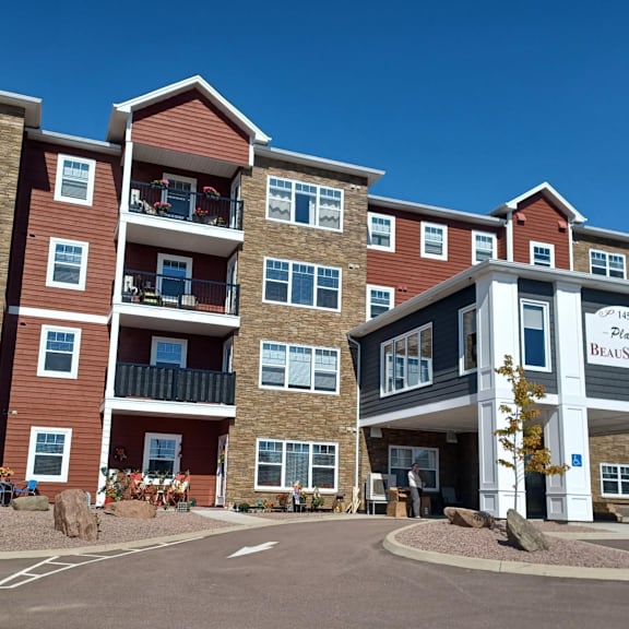 the image shows a multi-story residential building with a clear blue sky in the background.