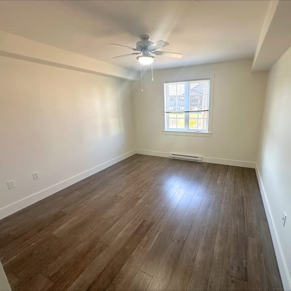 a room with a ceiling fan and a window.