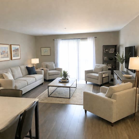 a living room with a white couch, a coffee table, and a television.
