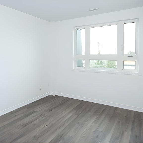 a room with a window and wooden flooring.