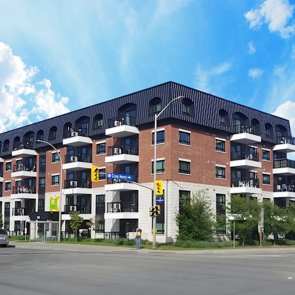 a large red brick building with a black roof and balconies.