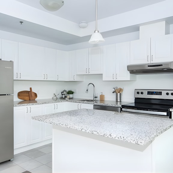 a modern kitchen with a stainless steel refrigerator and a marble countertop.
