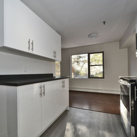 a modern kitchen with white cabinets and black countertops.