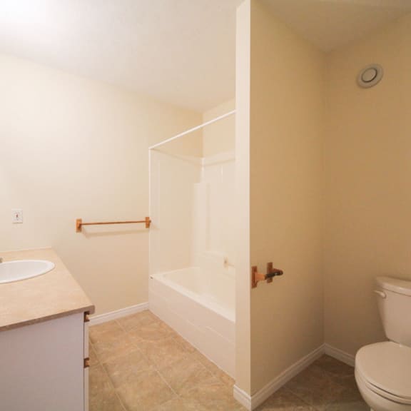 a bathroom with a toilet, sink, and bathtub.