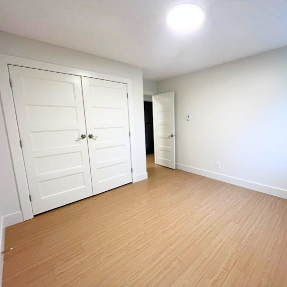 a room with a white door and a wooden floor.