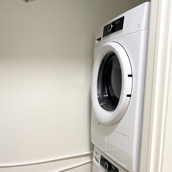 a white front loading washing machine in a laundry room.