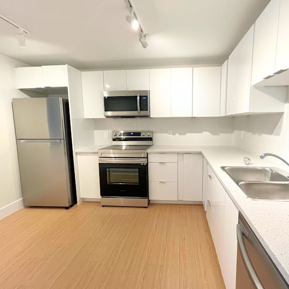 a kitchen with white cabinets and stainless steel appliances.