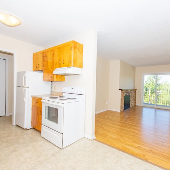 a kitchen with white appliances and wooden cabinets.